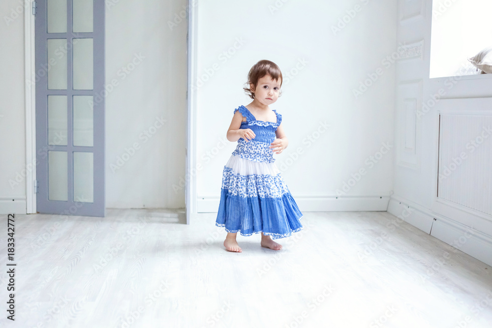 Funny and cute brunette little smiling girl playing and dancing in bright room Funny and cute brunette little smiling girl playing and dancing in bright room