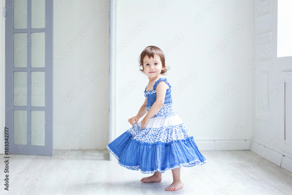 Funny and cute brunette little smiling girl playing and dancing in bright room Funny and cute brunette little smiling girl playing and dancing in bright room