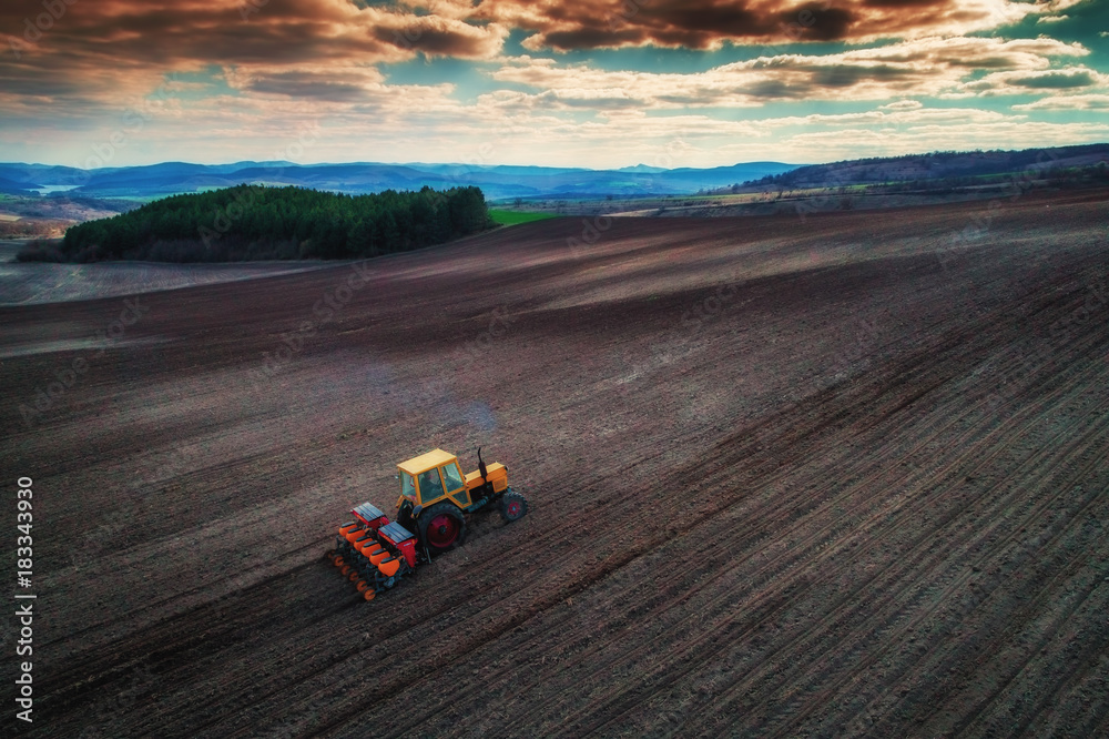 Aerial view of tractors working on the harvest field