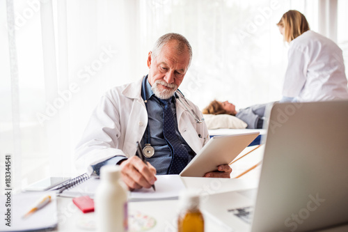 Senior doctor with tablet in his office.