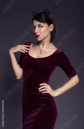 Portrait of a beautiful brunette caucasian woman with short straight hair and red lips on a neutral grey background. Romantical sexy mood