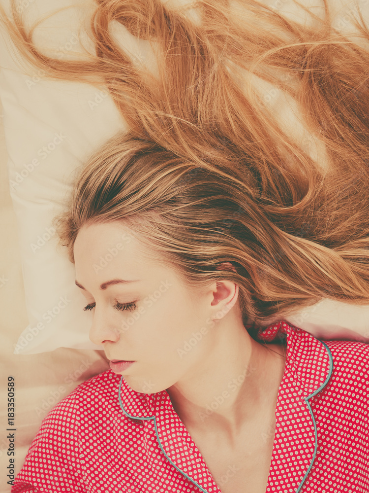 Young woman lying on bed wearing pajamas Young woman lying on bed wearing pajamas