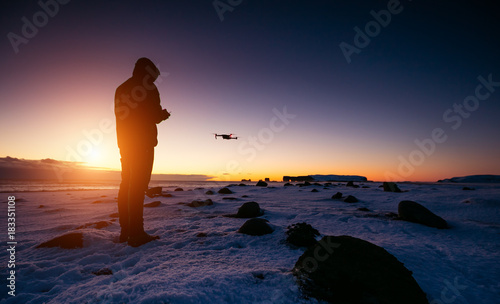 Drone pilot with unmanned aircraft in beautiful sunset ligt. Modern technology and outdoor activity