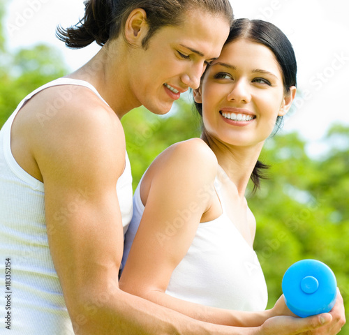 Cheerful couple with dumbbells on workout