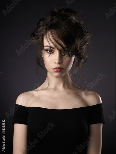 Beautiful woman with elegant hairstyle on black background