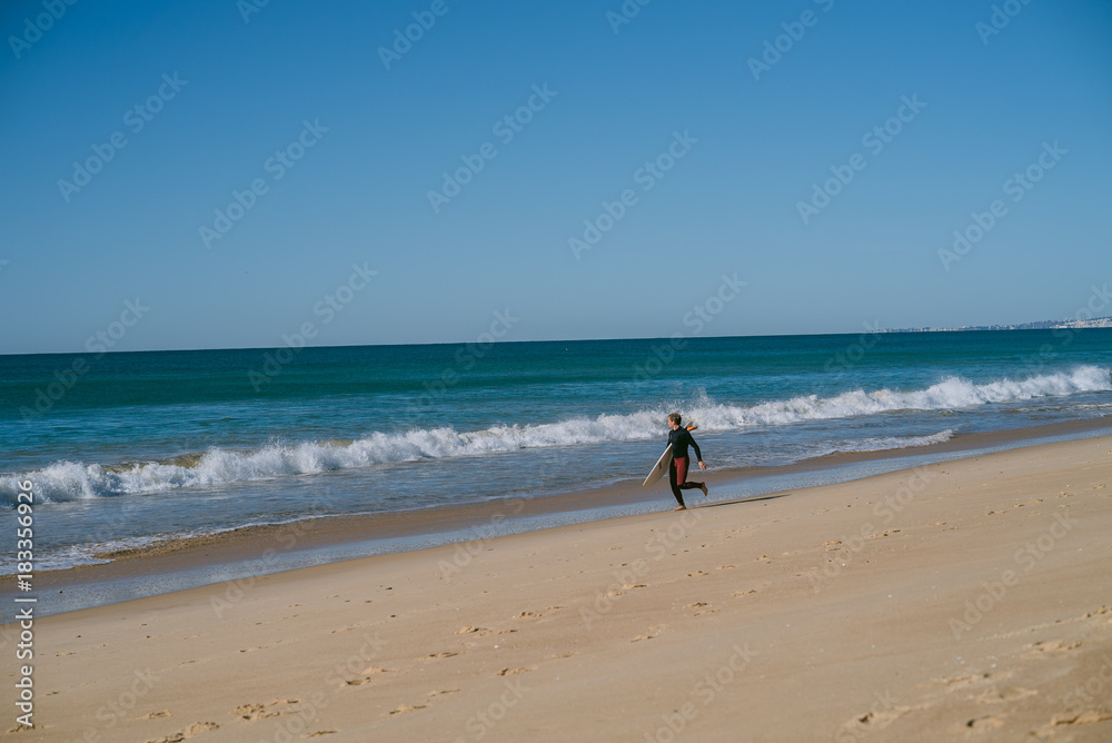 Man on the beach with surfboard in Portugal warming up