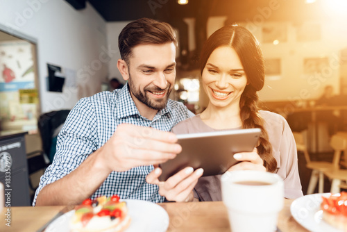 A guy and a girl celebrate a holiday on March 8 in a cafe.