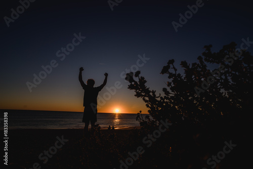 Man watching the sunset with hands up in Portugal © Nena