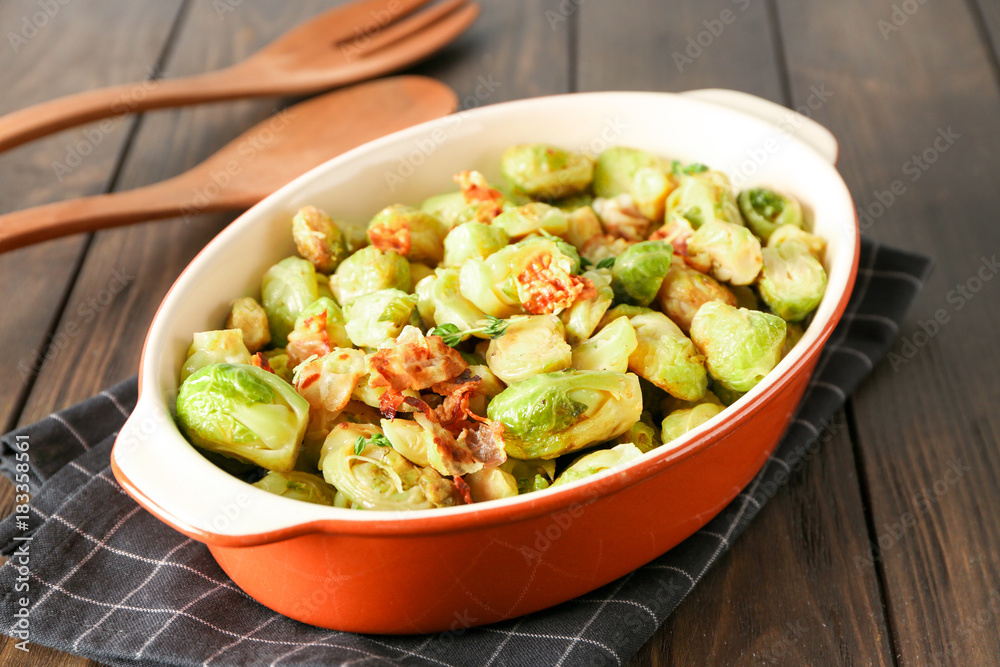 Casserole with Brussels sprouts and bacon on wooden table Casserole with Brussels sprouts and bacon on wooden table