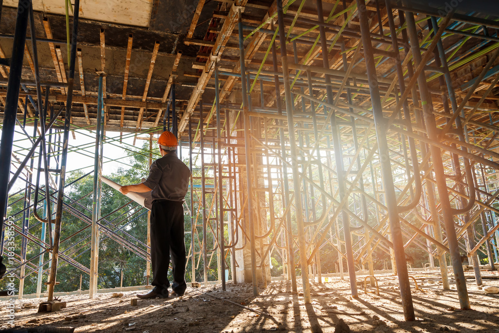 Engineer or foreman with blueprint in building construction site Engineer or foreman with blueprint in building construction site