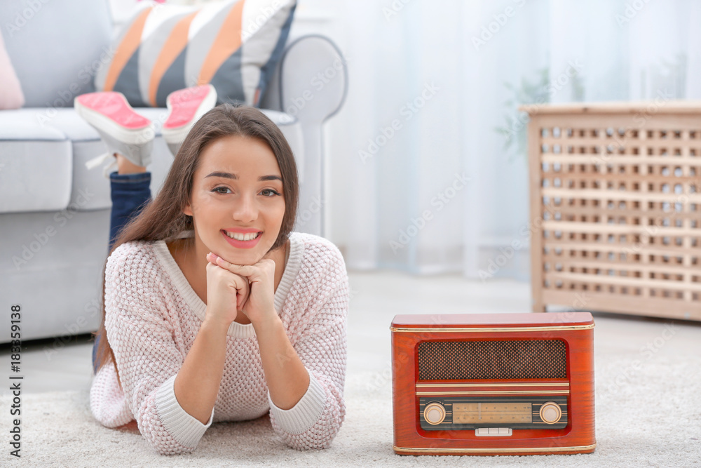 Young woman listening to radio while lying on carpet in room Stock Photo |  Adobe Stock