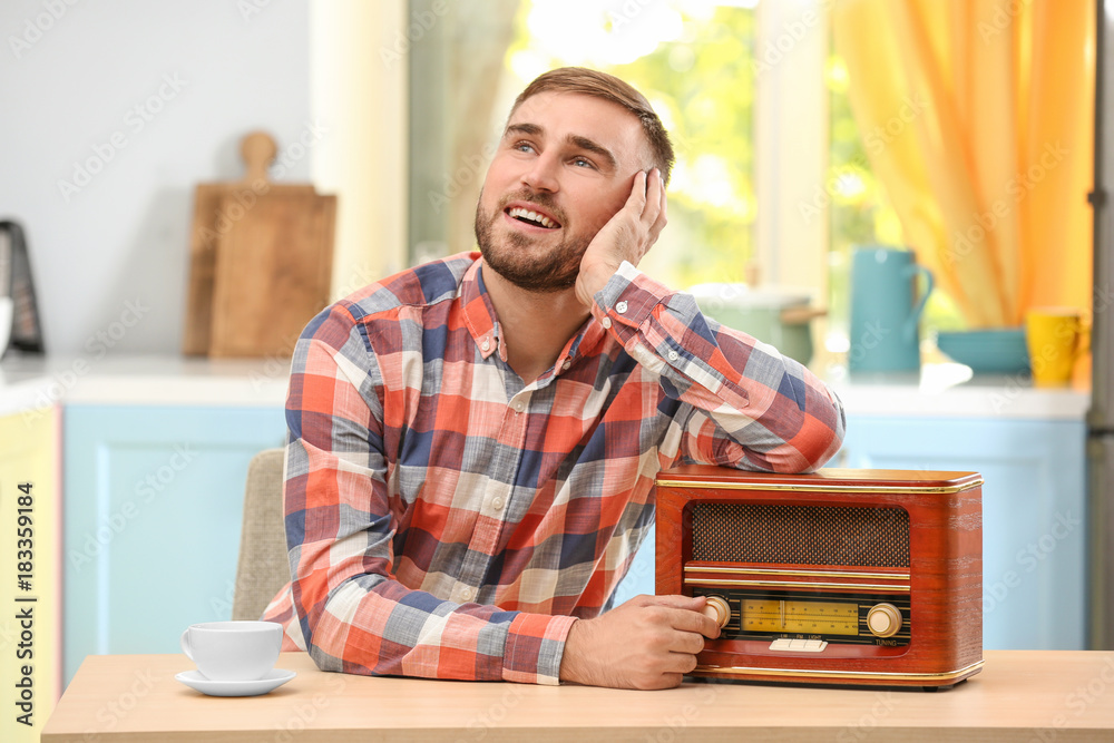 Young man listening to radio in kitchen Stock Photo | Adobe Stock