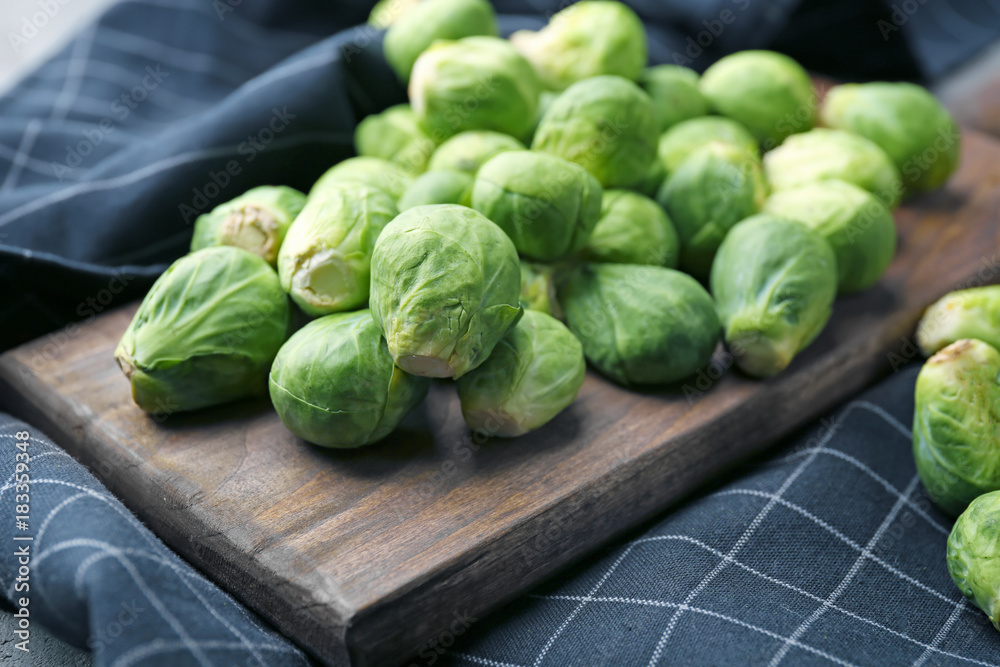 Wooden board with fresh raw Brussels sprouts on table Wooden board with fresh raw Brussels sprouts on table