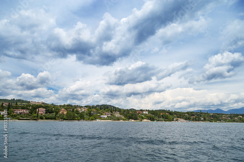 Natural scenery of lake Garda. The view from the water on the coast of the small Italian town of Padenghe.