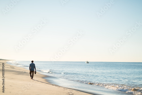 Man watching the sunrise and walking around on the beach in Portugal