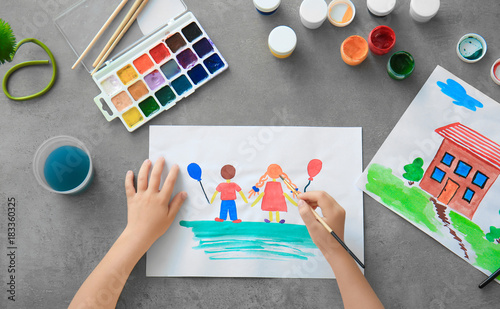 Little girl painting at table