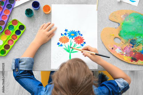 Little girl painting at table