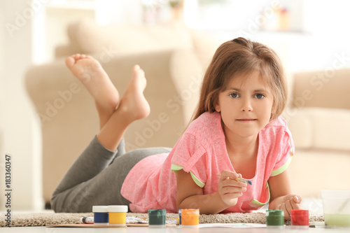 Little girl painting on floor