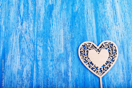 wooden heart carved on a blue wooden background. space for text