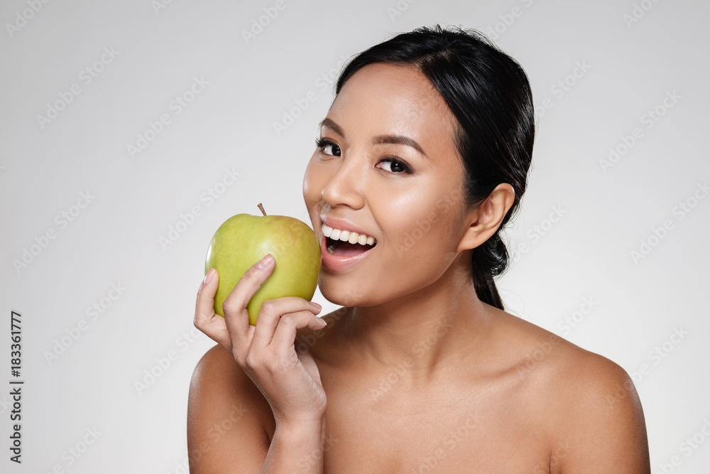 Cheerful lady smiling and eating green apple isolated Cheerful lady smiling and eating green apple isolated