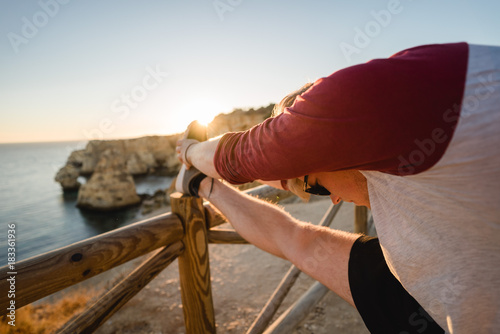 Man stretching at sunset on a cliff