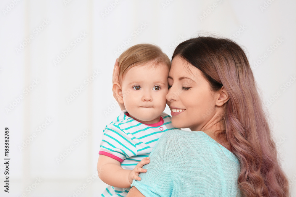 Young mother with baby on light background Young mother with baby on light background