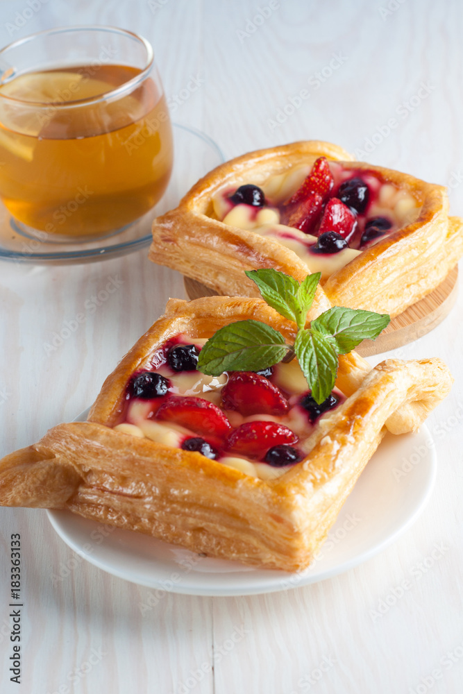 Fresh fruit tart with berries jam decorated with cranberry, mint on wooden rustic background wit a cup of tea. Desert. Morning healthy breakfast and evening dinner. Fresh fruit tart with berries jam decorated with cranberry, mint on wooden rustic background wit a cup of tea. Desert. Morning healthy breakfast and evening dinner.