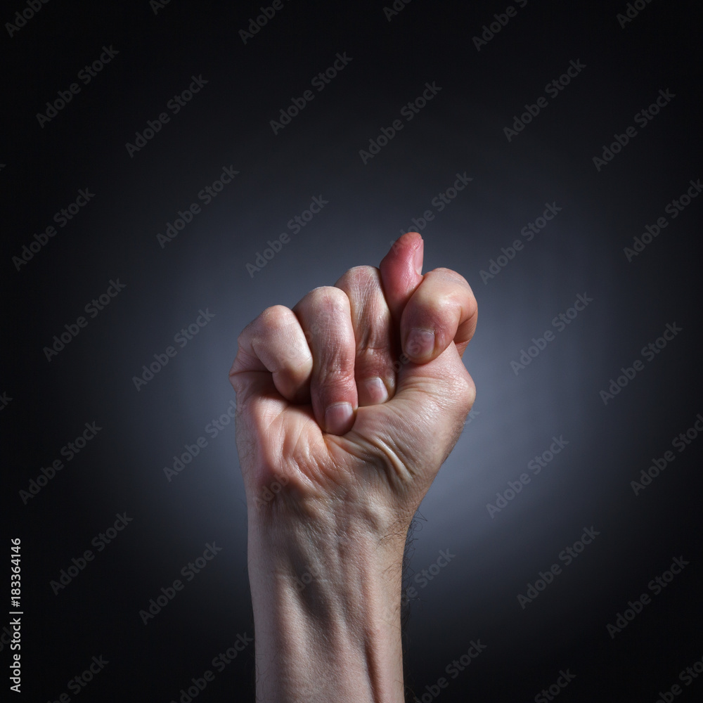 The human hand in a gesture of blowing closeup on dark background. The human hand in a gesture of blowing closeup on dark background.
