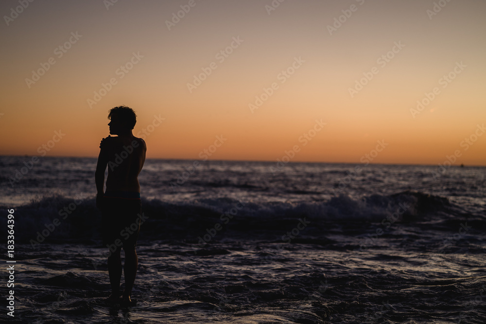 Man standing on a rock at sunset