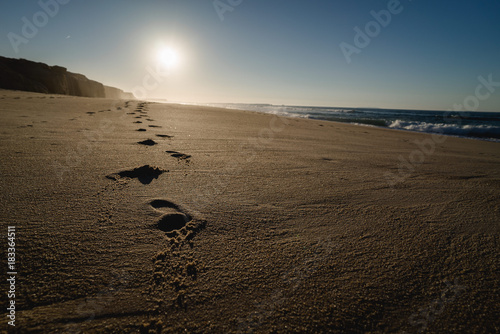 Footsteps on the beach in Portugal at sunset