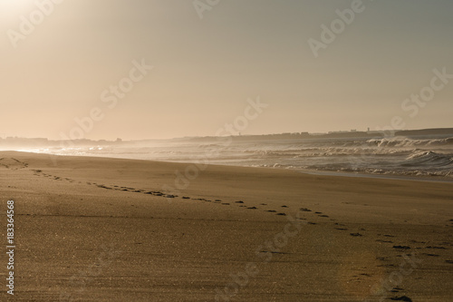 Footsteps on a beach in Portugal at sunset