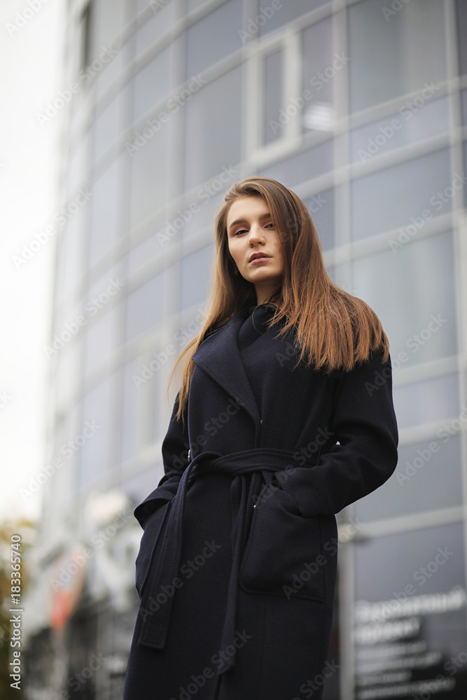 Beautiful girl in a coat in business downtown 