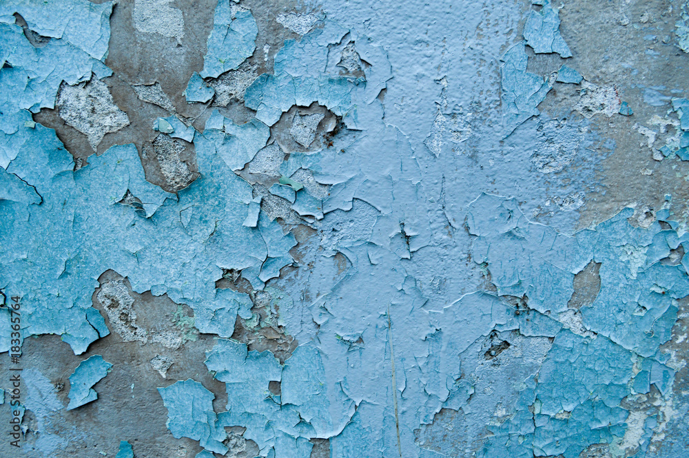 Old, blue, exfoliated, peeling paint on the concrete wall. The background. Texture.