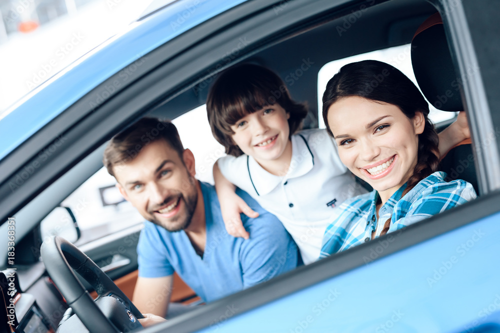 A woman is sitting at the wheel of a new car. A woman is sitting at the wheel of a new car.