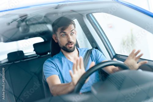 A man is sitting at the wheel of the car.
