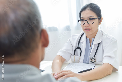 Female doctor comforting senior male patient.