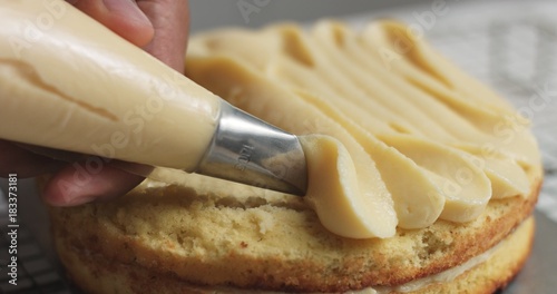 Adding cream and fruit to cake
