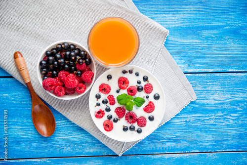 tasty yoghurt with raspberry on wood blue table