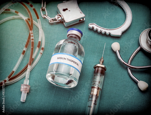 Handcuffs next to a vial of sodium thiopental and drip irrigation equipment with traces of blood, concept of capital punishment, conceptual image photo