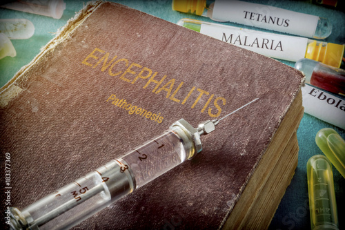 Vintage Syringe On A Book Of encephalitis, Medical Concept photo