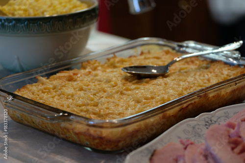 Photography Home-cooked cheesy potatoes in glass casserole dish