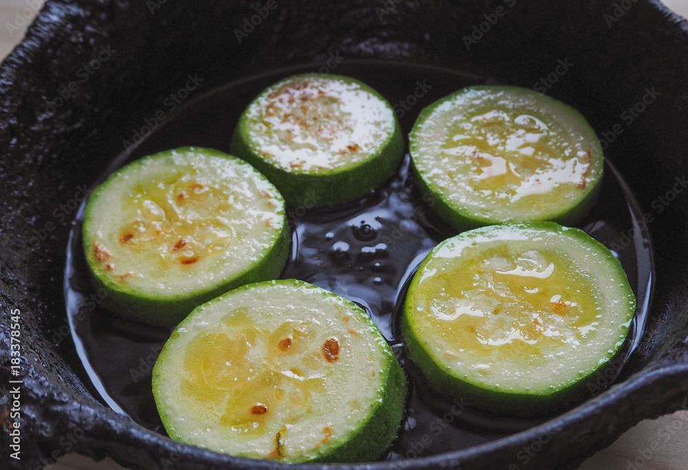 Appetizing fried zucchini in an old pan. 