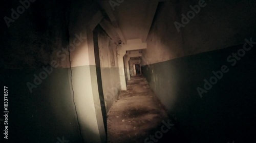 Moving through dark creepy corridor. First person view, going with flashlight in dirty grungy tunnel in abandoned building, horror escape concept, toned photo