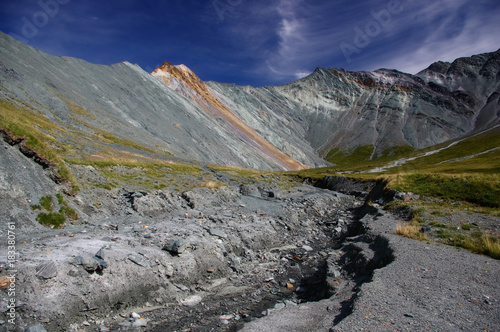 Mountain valley with river stream rocks and green grass on the background colored colorful white gray peaks Yarlu valley Altai Mountains Siberia, Russia photo