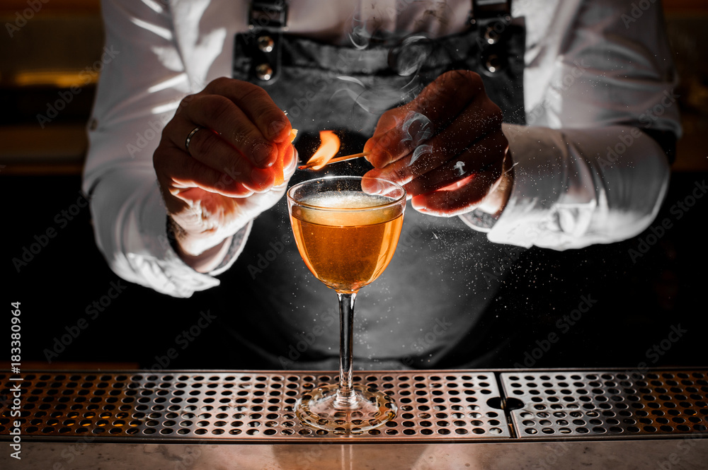Barman hands making a fresh alcoholic drink with a smoky note