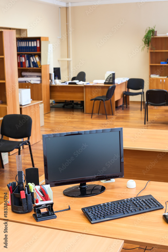 Fototapeta premium Black lcd computer monitor is off in empty office room after the end of the working day