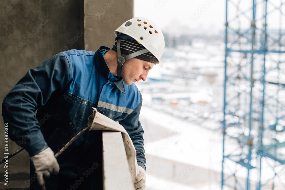 Construction worker in uniform and helmet preparing rope..Risky work at height Construction worker in uniform and helmet preparing rope..Risky work at height