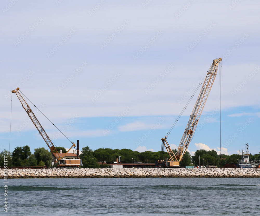 cranes and construction site in the sea for building a dam