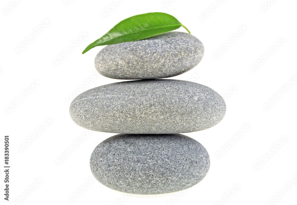 Fototapeta premium Green leaf with spa stones, isolated on white background