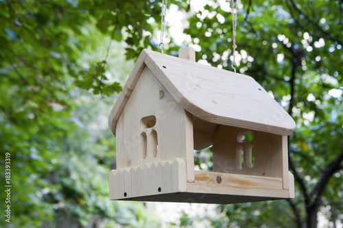 the Wooden bird feeder on a pole in the summer wood